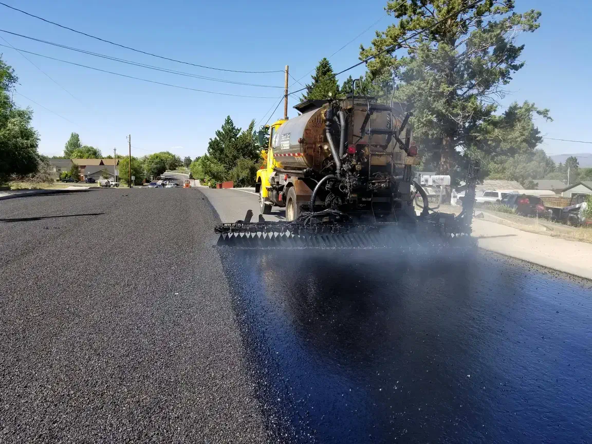 Asphalt sealcoating truck applying commercial-grade sealcoat