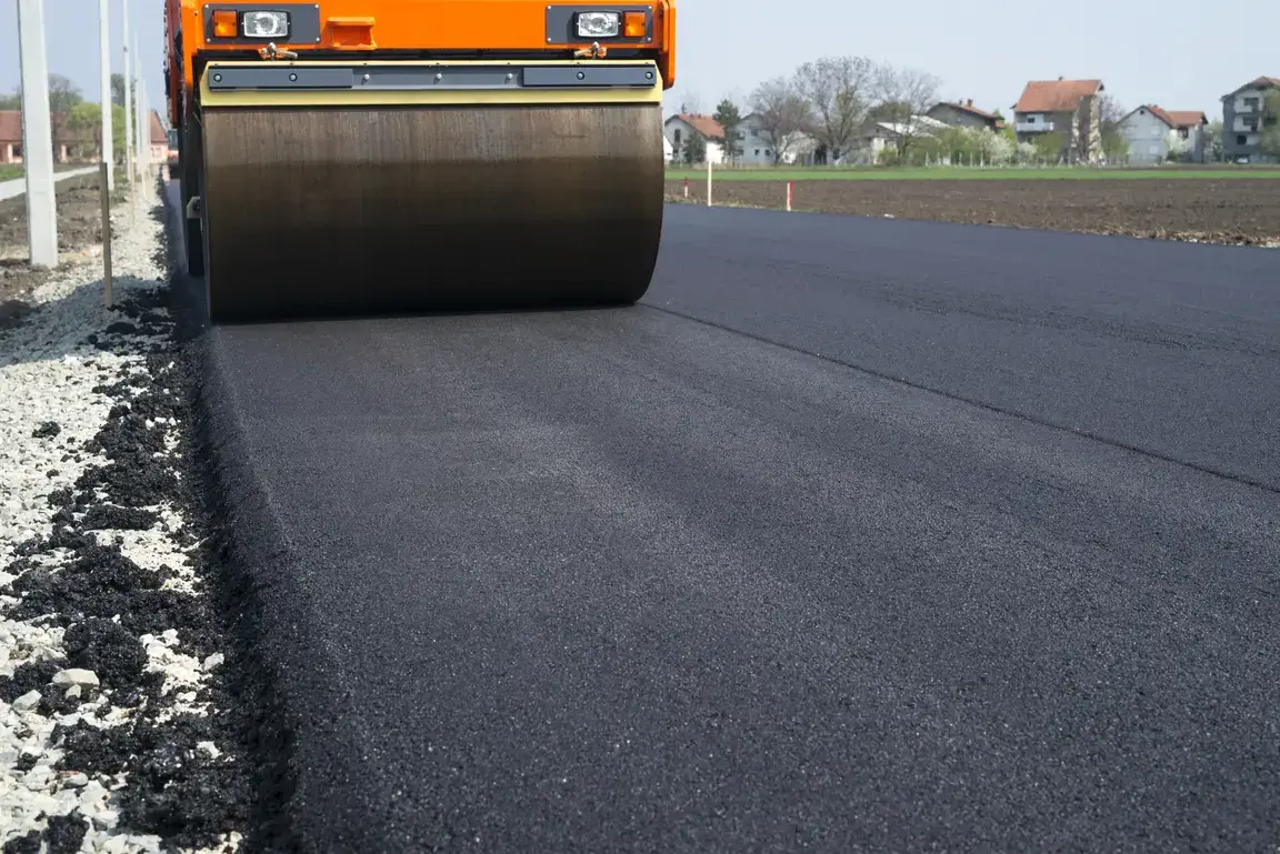Roller compacting fresh asphalt during a paving and repair project
