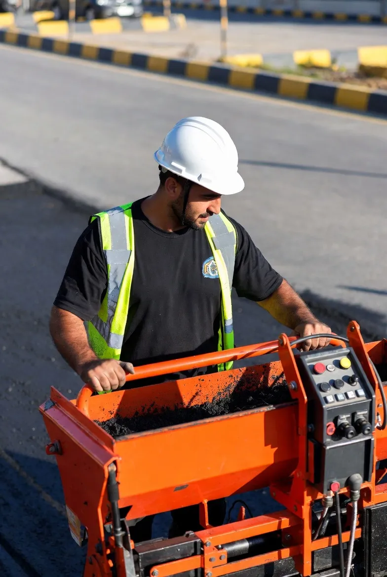 Oak Hill Nashville Asphalt Services Asphalt worker operating a plate compactor during commercial asphalt service work