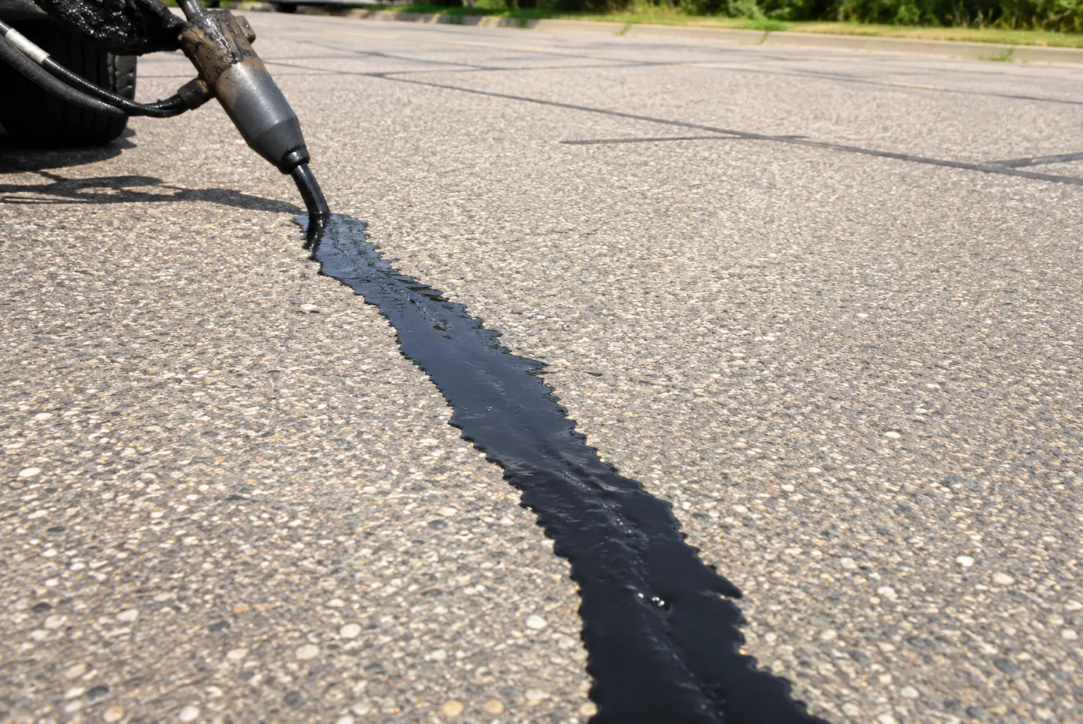 Asphalt crack filled with hot rubber sealant to stop water damage